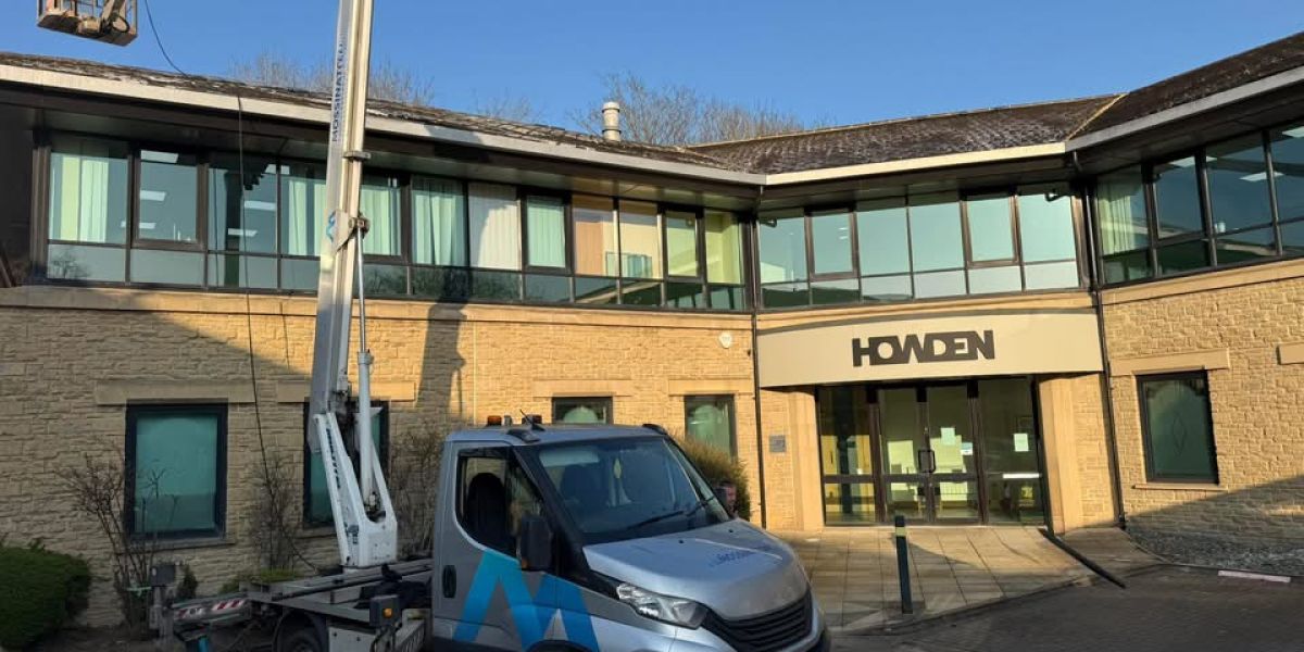 A truck parked in front of a building, showcasing its large size against the structure behind it.