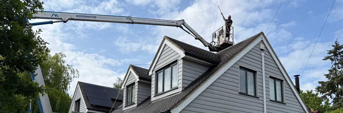 A man operates a cherry picker while working on a chimney, focusing on maintenance and repairs from an elevated position.  