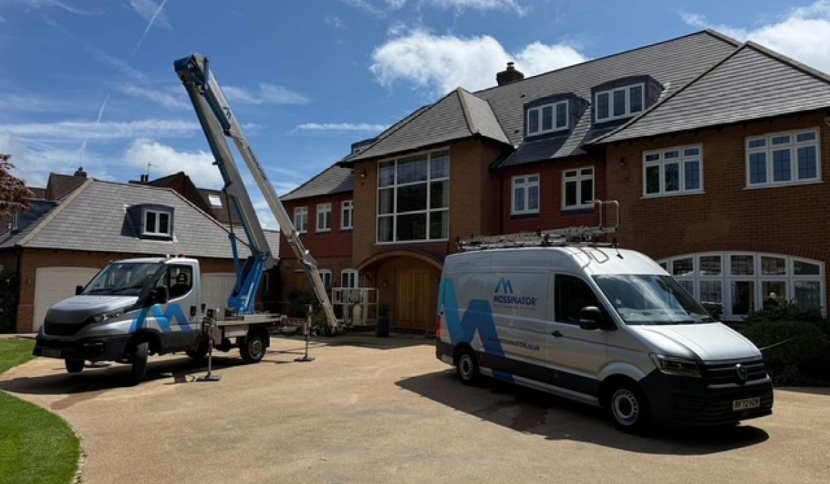 Mossinator roof cleaning vans outside a residential property in Beaconsfield, with specialist access equipment set up on the driveway.